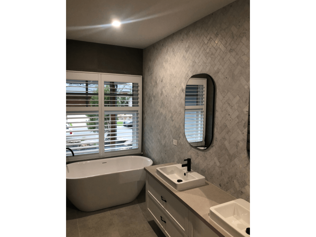 Bathroom with venetian style open blinds and large bath and modern double basins