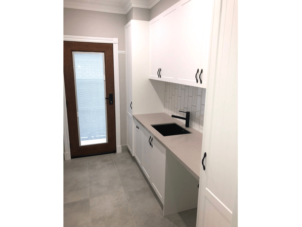 Officer Wide open space laundry area with cupboards and basin